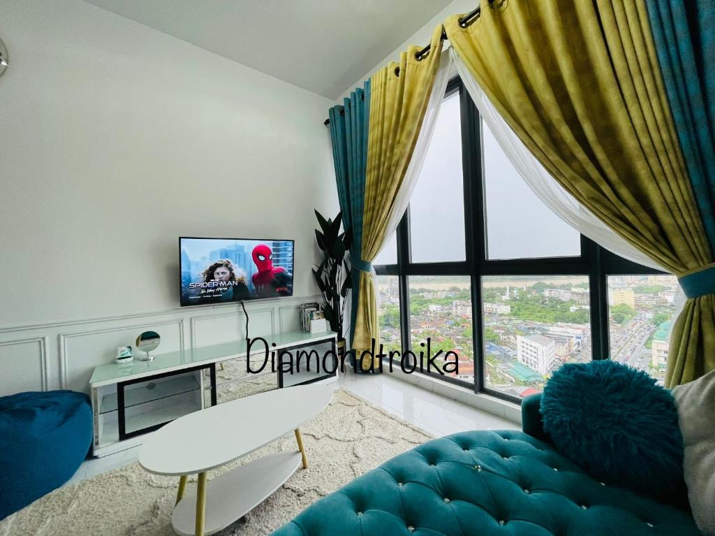 sala de estar con sofá azul y ventana grande en Diamond@Troika, en Kota Bharu