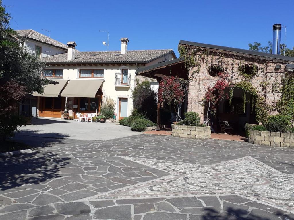 ein großes Gebäude mit einem steinernen Innenhof davor in der Unterkunft Agriturismo Melo in Fiore in Maser