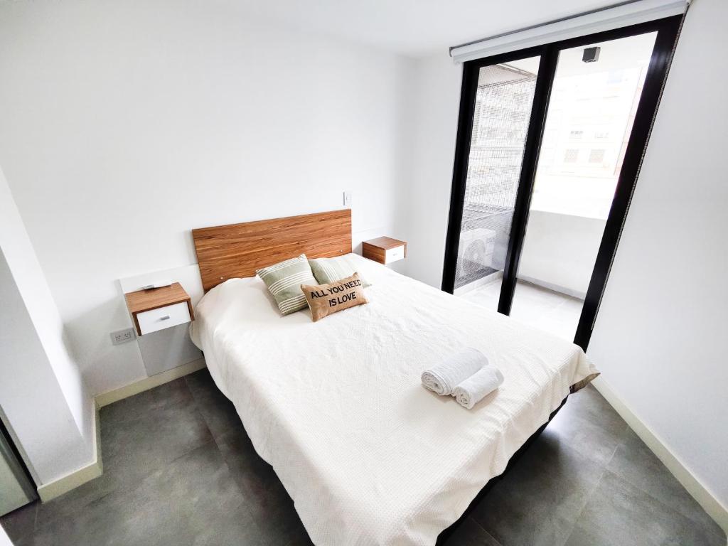 um quarto com uma cama branca com duas toalhas em Tu lugar en Córdoba - Departamento Premium em Córdova