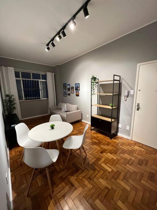 uma sala de estar com uma mesa e cadeiras e um sofá em Apartamento Nictheroy em Niterói