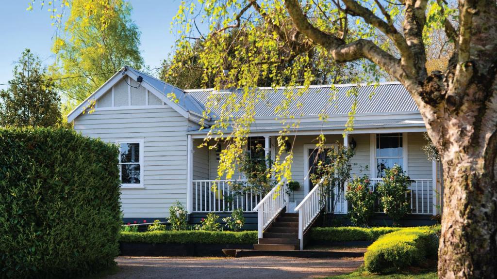 ein weißes Haus mit einem Baum davor in der Unterkunft Little Wombat Daylesford Complimentary EV Station in Daylesford