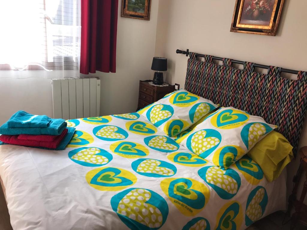 a bed with a comforter and pillows on it at CHEZ ANTOINE in Saint-Pierre-dels-Forcats