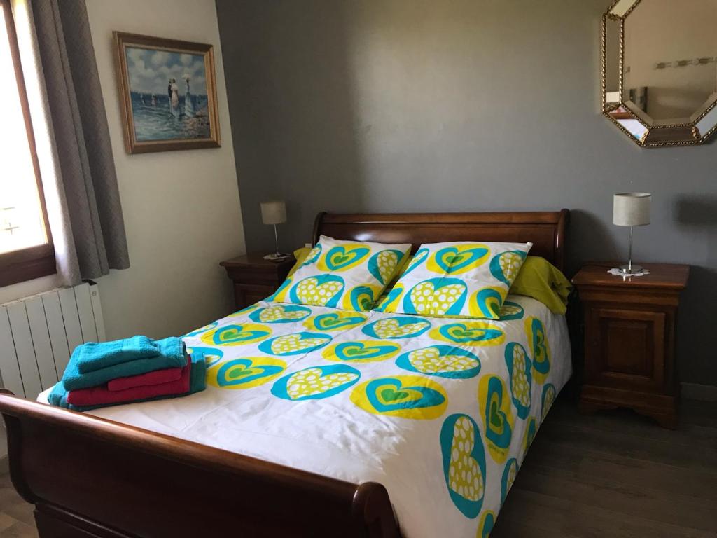 a bedroom with a bed with a colorful comforter at CHEZ ANTOINE in Saint-Pierre-dels-Forcats