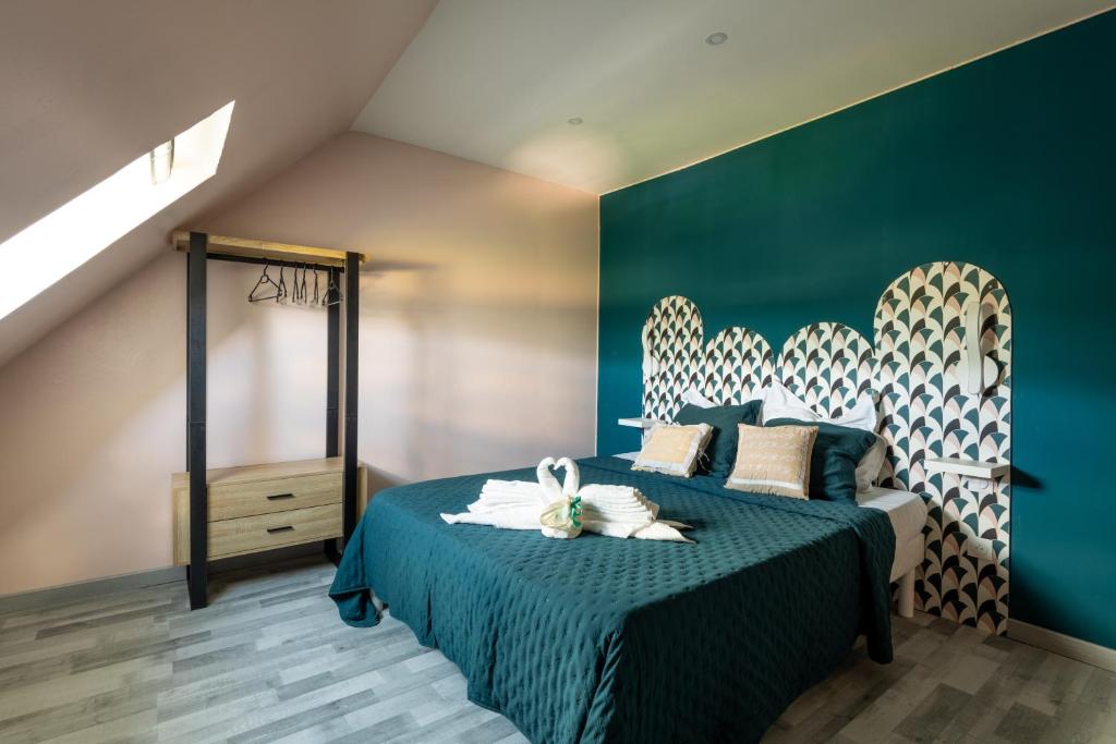 - une chambre avec un lit et un mur vert dans l'établissement LA TOULOTTE chez Claire et Christian, à Sancy-lès-Provins