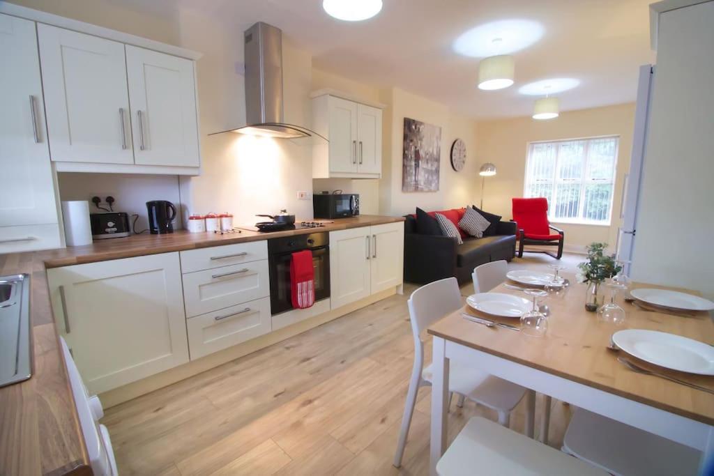 a kitchen and living room with a table and a dining room at Newly refurbished village flat in Cullybackey