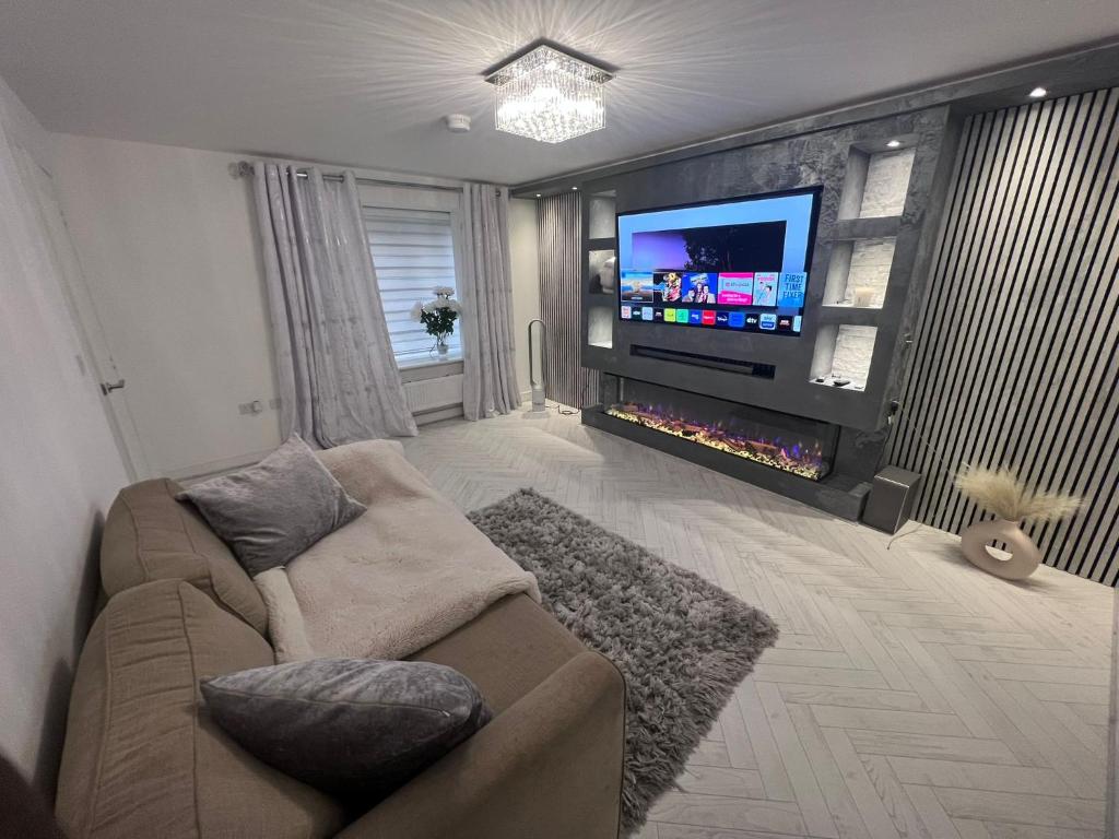 a living room with a couch and a flat screen tv at Lancaster Close, 14 in Greenhithe
