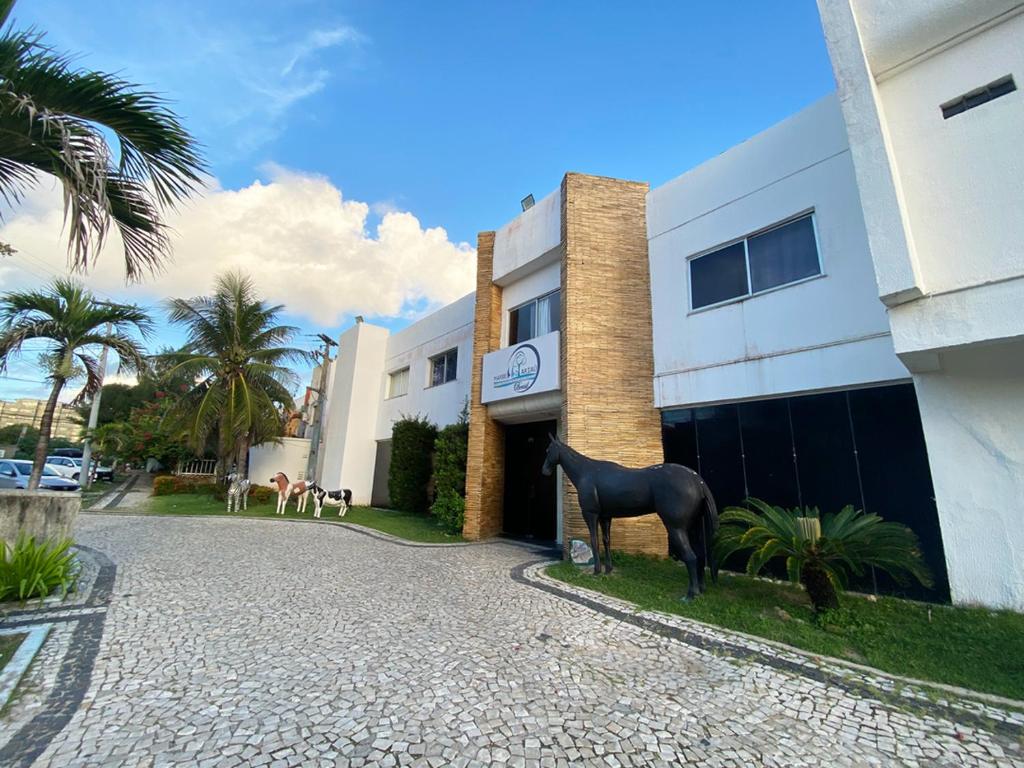 une statue de cheval debout devant un bâtiment dans l'établissement Marbello Ariau Hotel, à Fortaleza