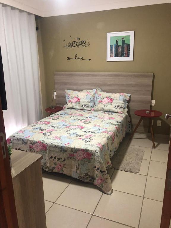 een slaapkamer met een bed met een quilt bij aldeia das aguas hotel in Além Paraíba