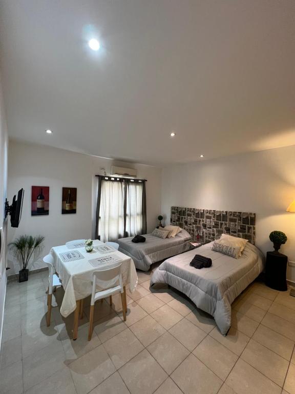 una camera da letto con due letti, un tavolo e delle sedie di Luminoso departamento céntrico a Corrientes