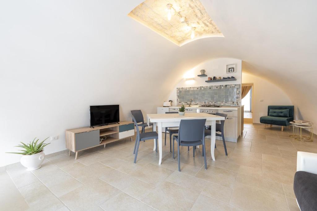 a kitchen and dining room with a table and chairs at Suite La Scala del Borgo in Cisternino