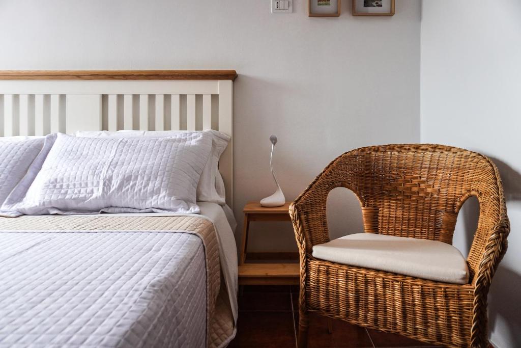 a bedroom with a bed and a wicker chair at Cozy Apartment in La Laguna in Las Lagunas