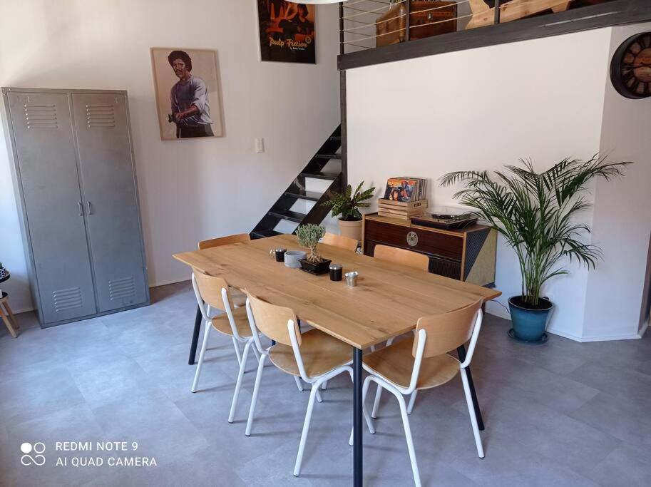 une salle à manger avec une table et des chaises en bois dans l'établissement Loft vue Palais des Papes, à Avignon
