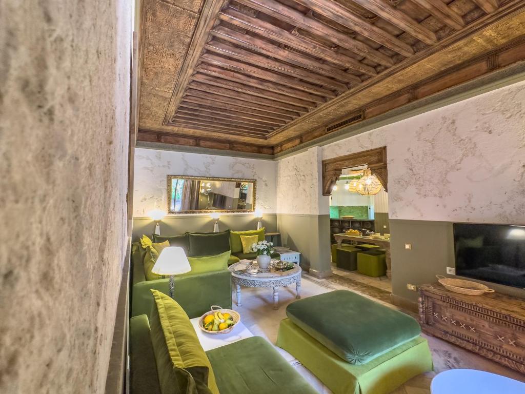 sala de estar con sillas verdes y mesa en Maison Maria Palmeraie, en Marrakech