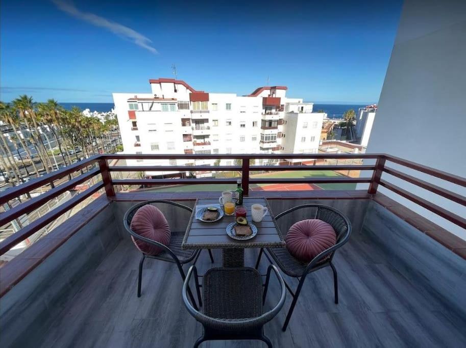 a table and chairs on a balcony with a view of the ocean at Apartamento céntrico de estilo nórdico in Adeje