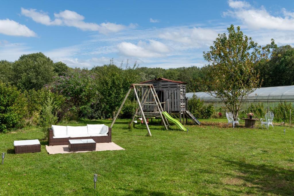 a swing set and a playground in a yard at LA TOULOTTE chez Claire et Christian in Sancy-lès-Provins
