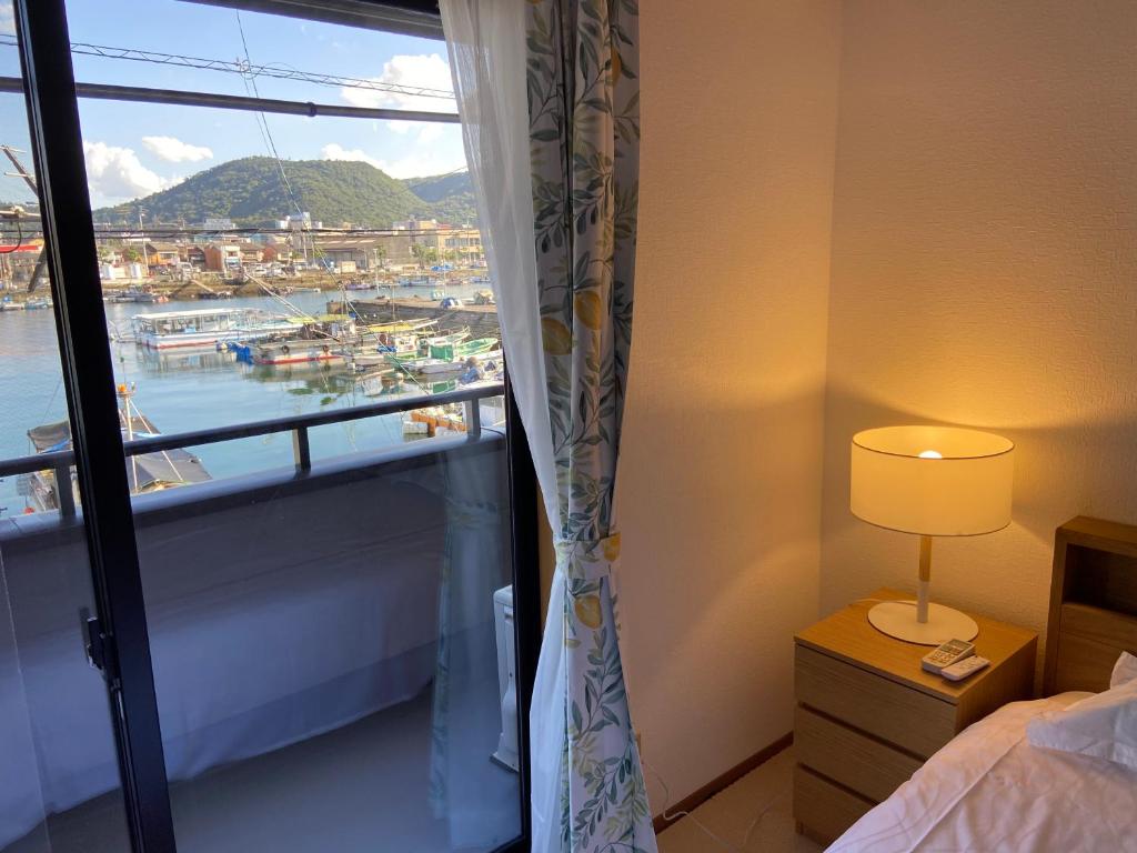 1 dormitorio con ventana y vistas al puerto en 浜町小院别馆 en Takamatsu