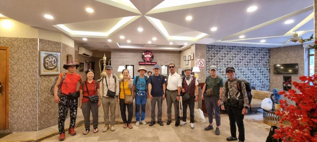 a group of people posing for a picture in a lobby at Grace Crown Hotel in Rawalpindi