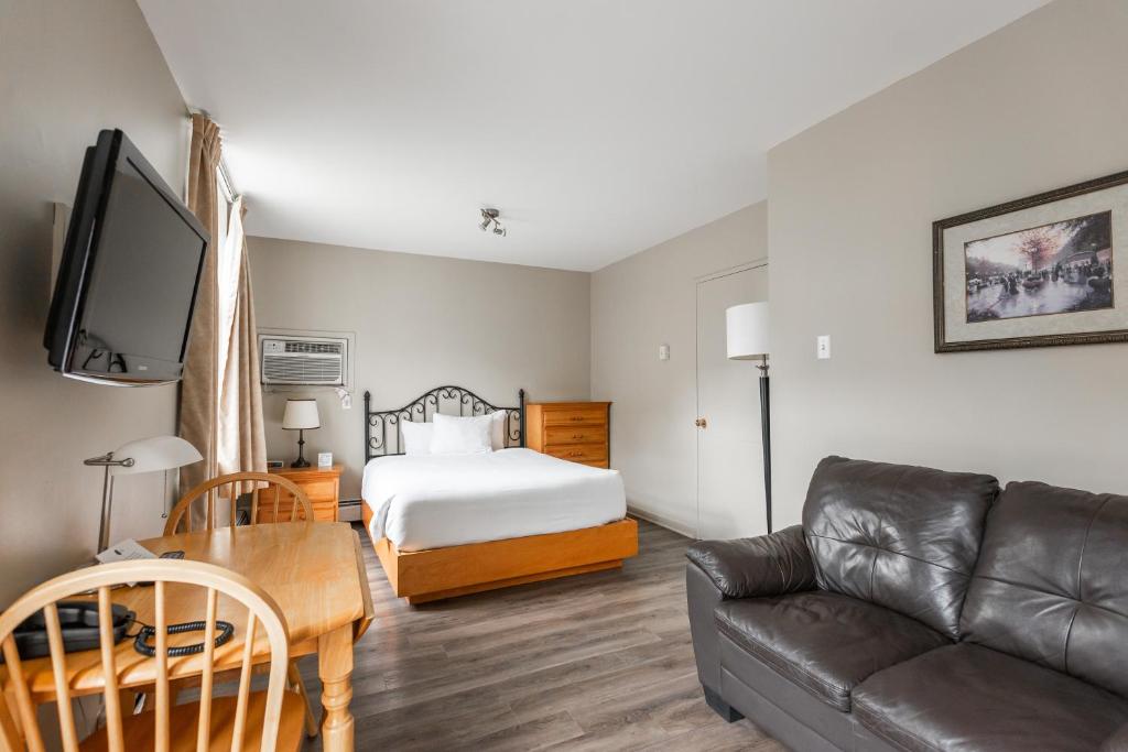 a living room with a bed and a couch at Hotel le Roberval in Montréal