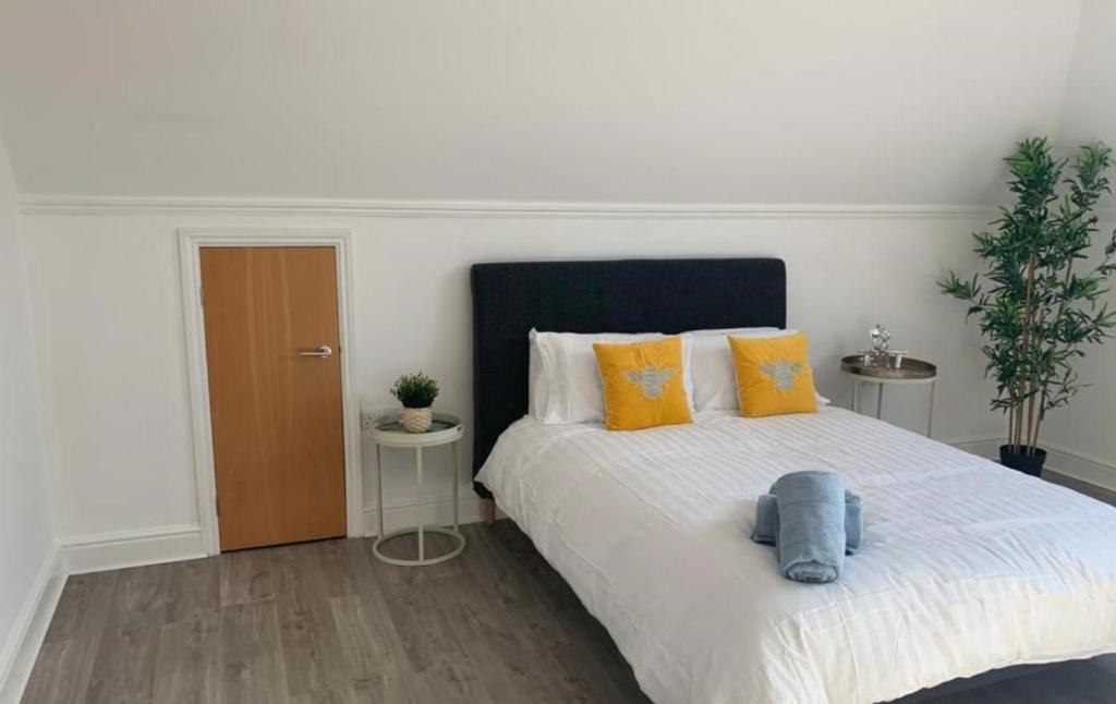 a bedroom with a large bed with orange and blue pillows at Addlestone - Large Stunning 2 bed room Apartment in Addlestone