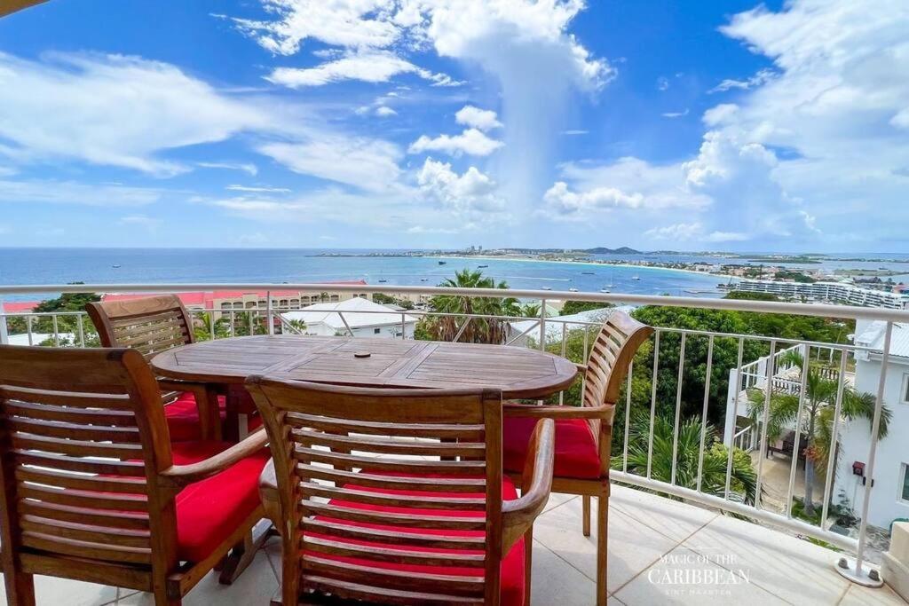 un tavolo e sedie su un balcone con vista sull'oceano di Villa Sea Forever @ Pelican Key - Paradise Awaits! a Simpson Bay