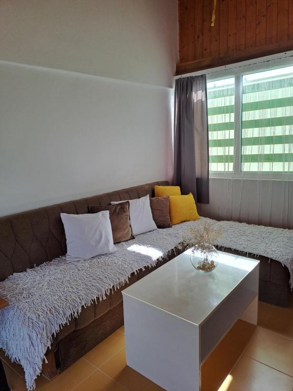 ein Wohnzimmer mit einem Sofa und einem Tisch in der Unterkunft Vikendica za odmor in Banja Luka