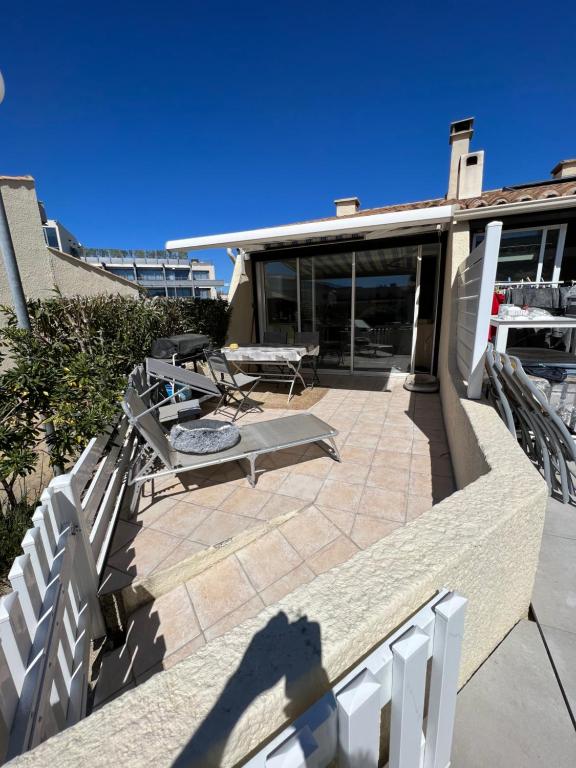 une terrasse avec une table et des chaises dans une maison dans l'établissement Helio 78, au Cap d'Agde