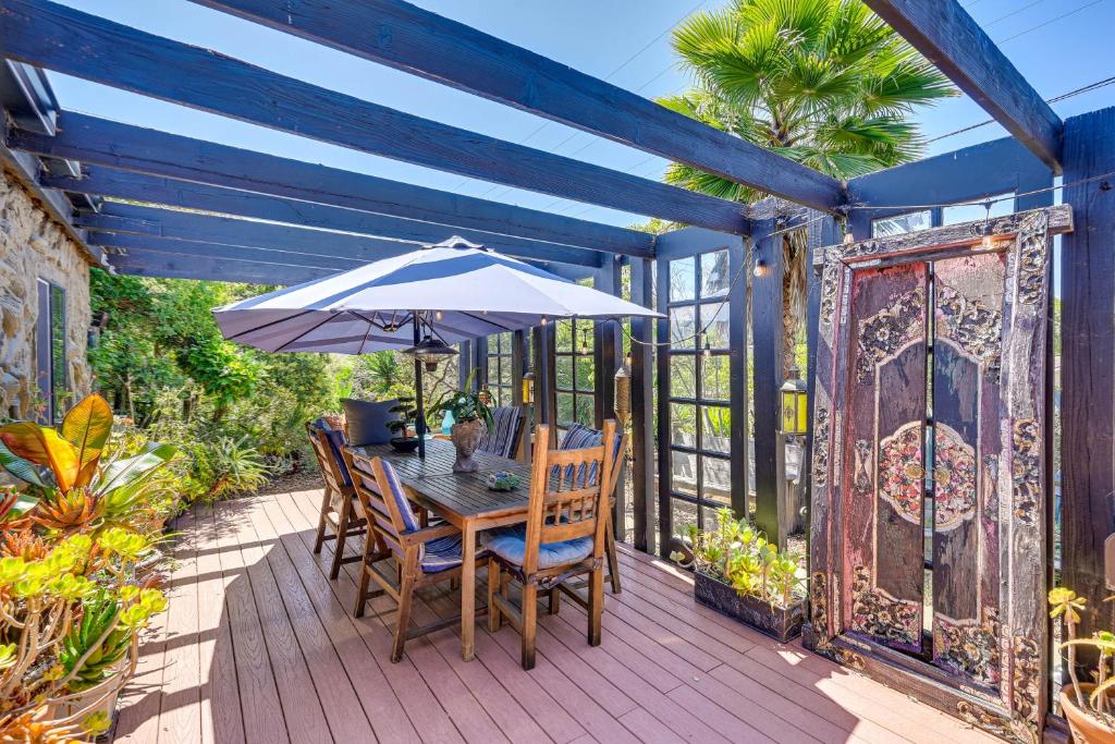 una mesa de madera con una sombrilla en la cubierta en Bohemian Wonderland Benicia Bungalow with Pergola!, en Benicia