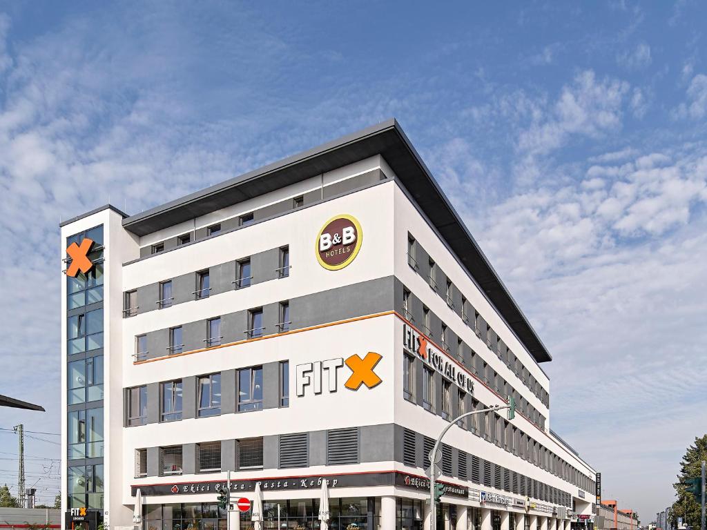 un gran edificio blanco con el logotipo del fedex en B&B Hotel Köln-Troisdorf, en Troisdorf