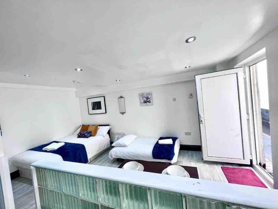 a room with two beds and a balcony at Studio Apartment in London in London