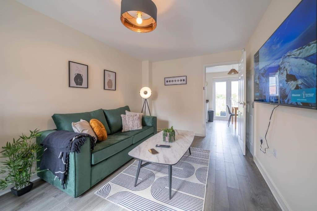 - un salon avec un canapé vert et une table dans l'établissement 2 bed house near Ricoh Arena, 2xparking, wifi, à Longford