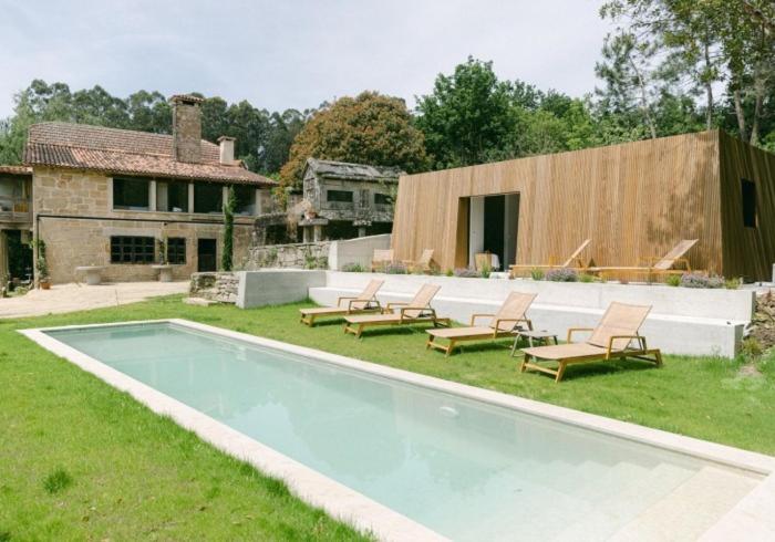 a swimming pool with lounge chairs and a house at Numa Experimental in Pontevedra