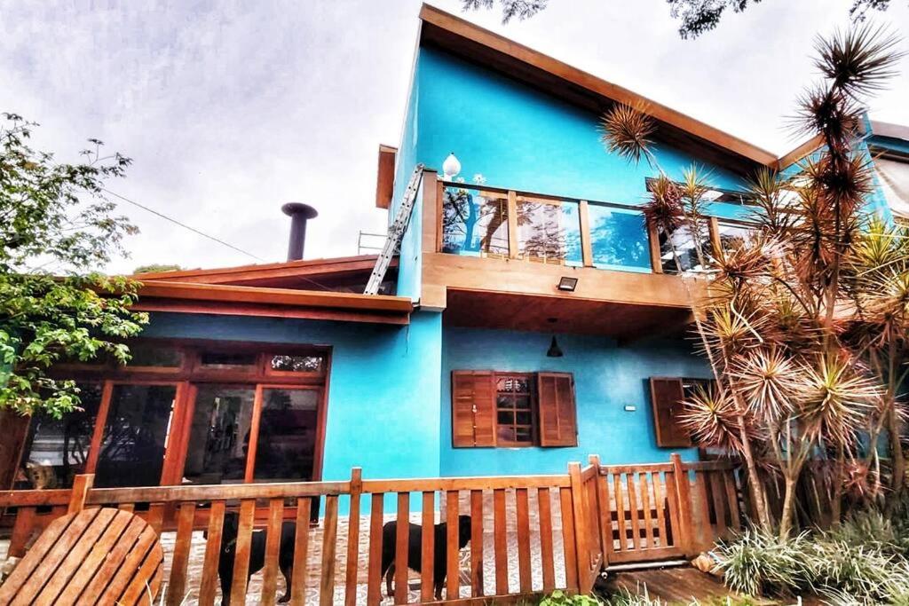 uma casa azul com uma cerca de madeira em frente em House Interlagos em São Paulo
