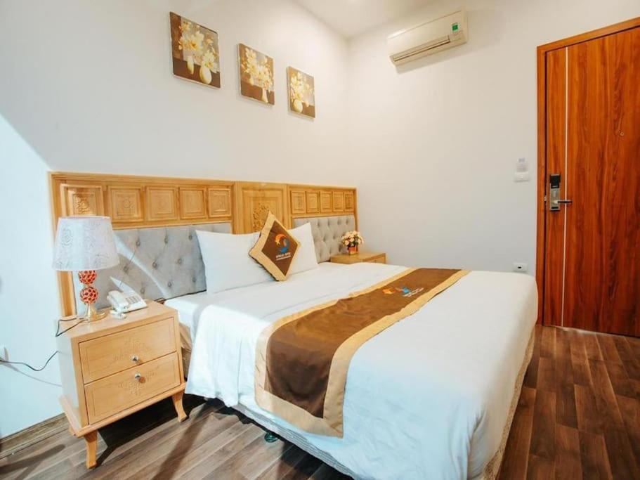 een slaapkamer met een groot bed en een nachtkastje bij GRAD Korea Hotel 2 in Làng Thành