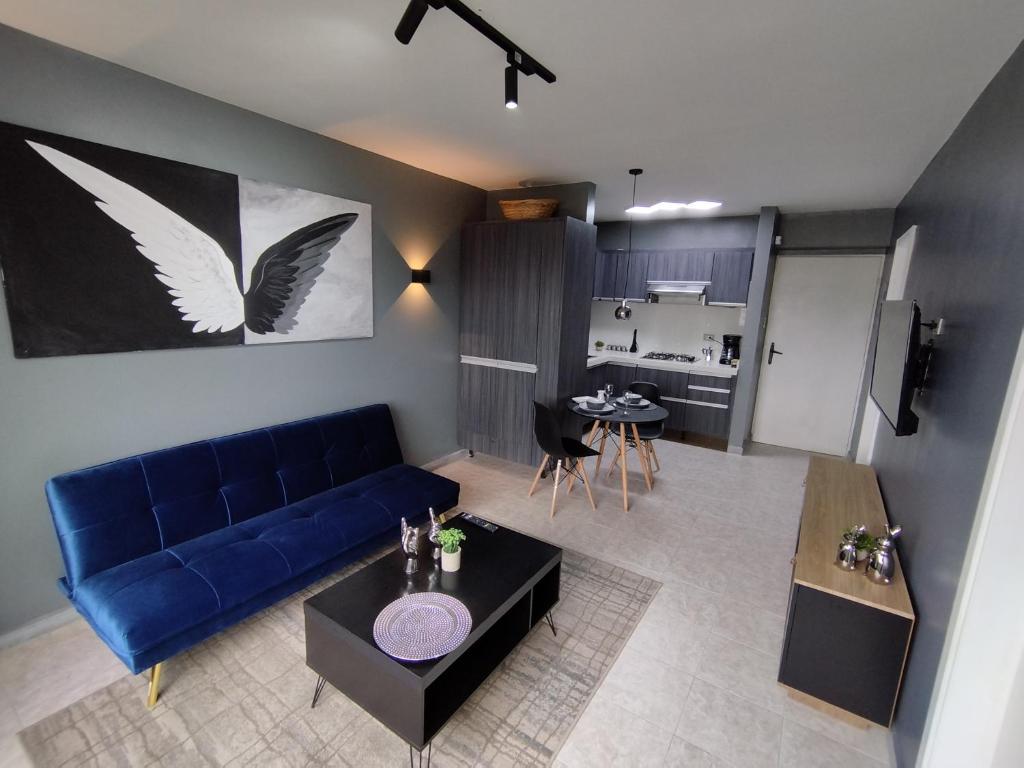 sala de estar con sofá azul y cocina en Chic y Hermoso Apartamento Amoblado y Equipado Los Mangos 3 Valencia-Venezuela en Valencia