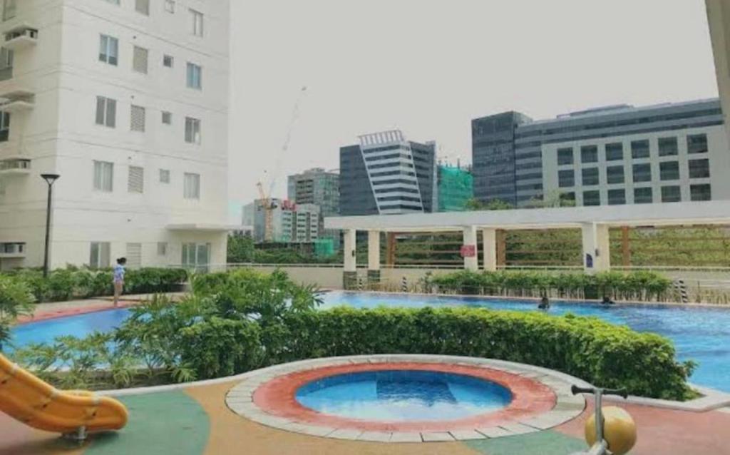 a large swimming pool in a city with buildings at Condo in Avida tower IT park , Lahug Cebu city, Fully furnished in Cebu City