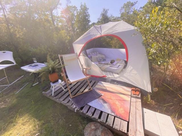 a tent with a table and chairs in a field at eco-dome off-grid garden glamping in Bithlo