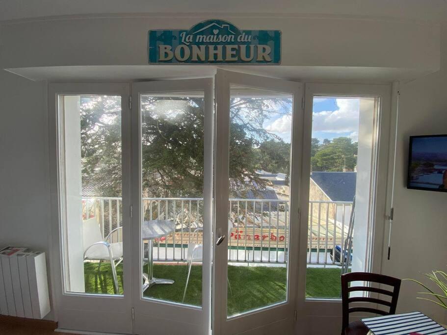 eine Glasschiebetür mit einem Schild darüber in der Unterkunft Appartement du bonheur ! Av de la Mer in Saint-Jean-de-Monts