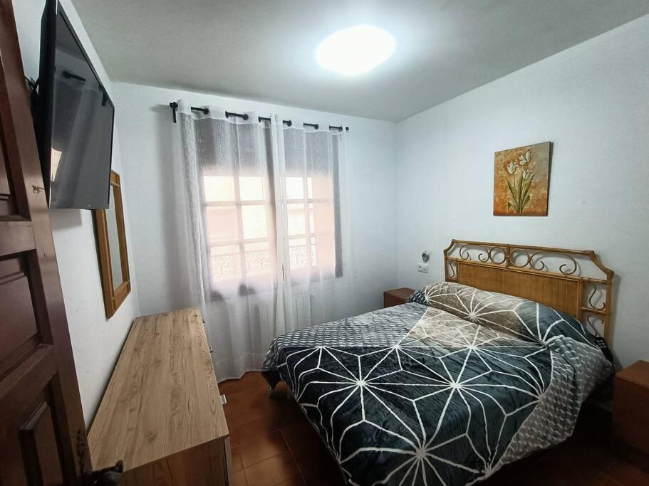 a bedroom with a bed and a television in it at Apartamento Casa de pueblo in Sant Feliu de Guixols