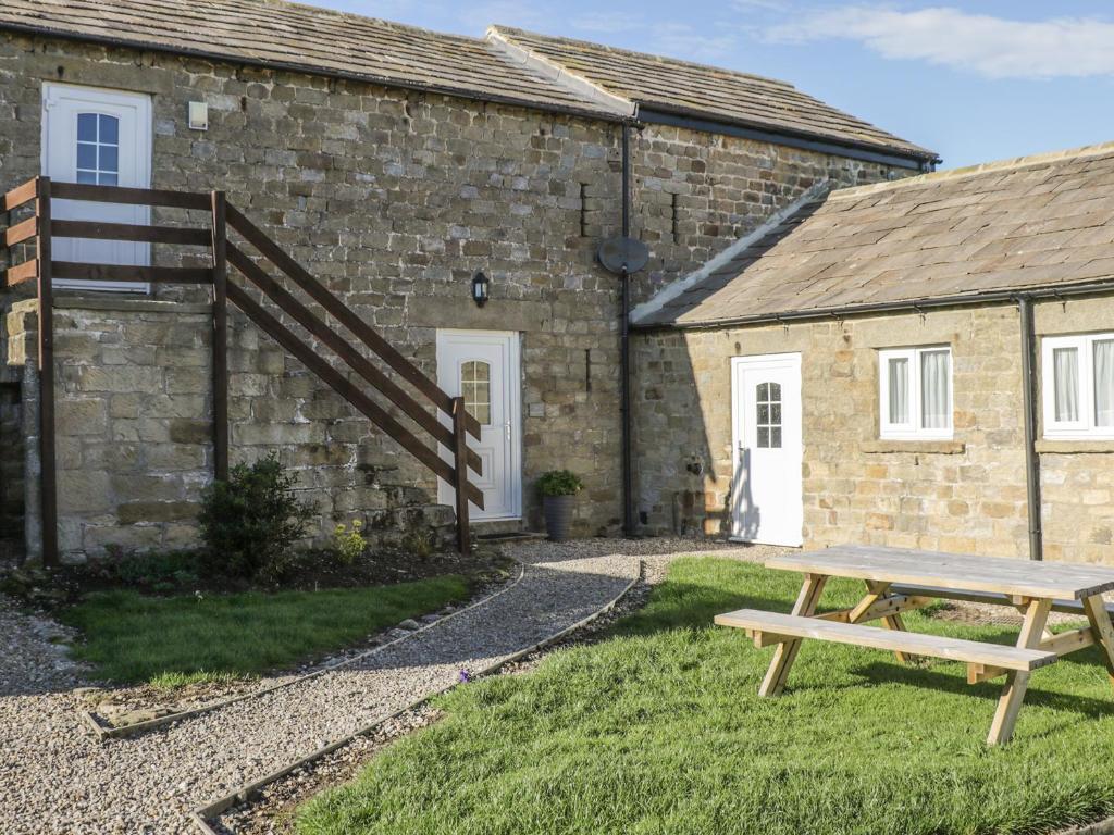 a picnic table in front of a stone building at The Hayloft in Ripon