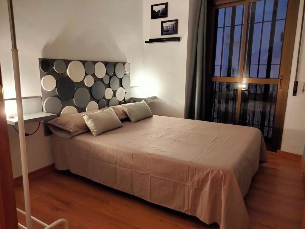 1 dormitorio con 1 cama grande y cabecero grande en Apartamento Con Encanto San Basilio, en Córdoba
