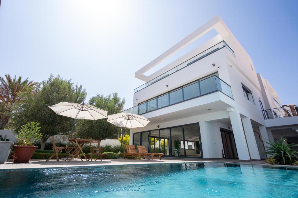 une villa avec une piscine et une maison dans l'établissement TigMAÏA Guest House In Agadir for Traditional Art and Culture, à Agadir