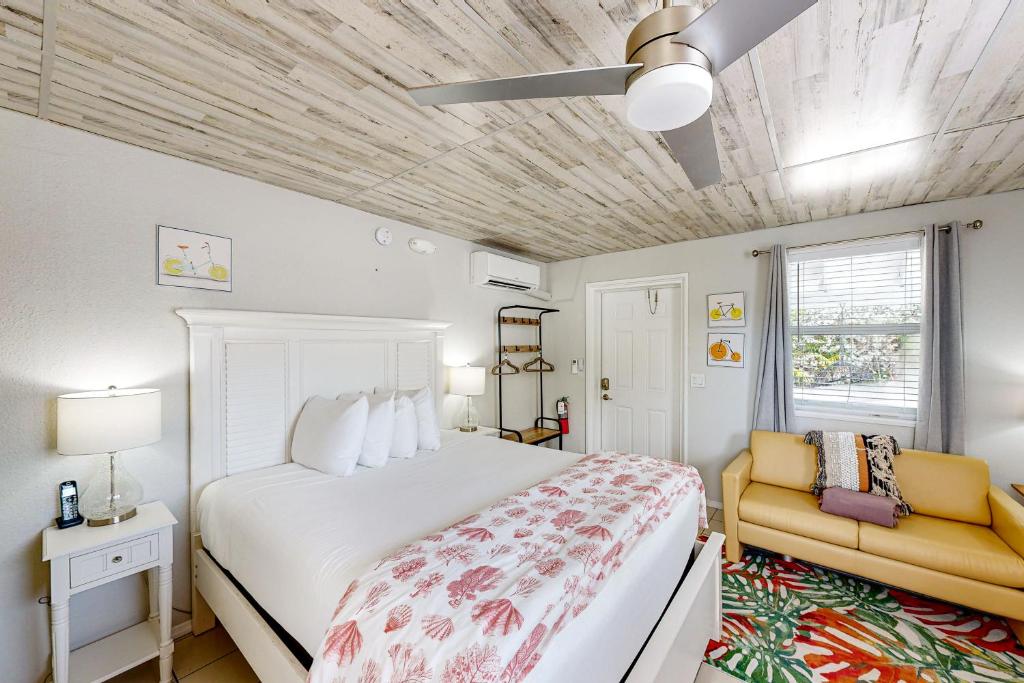 a bedroom with a white bed and a yellow chair at Citrus Room in Marathon