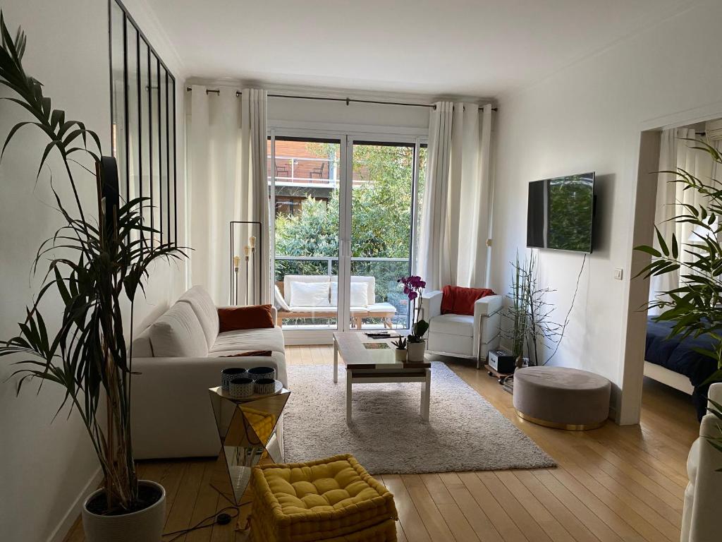 a living room with a couch and a table at Appartement 65m2 avec balcon in Neuilly-sur-Seine