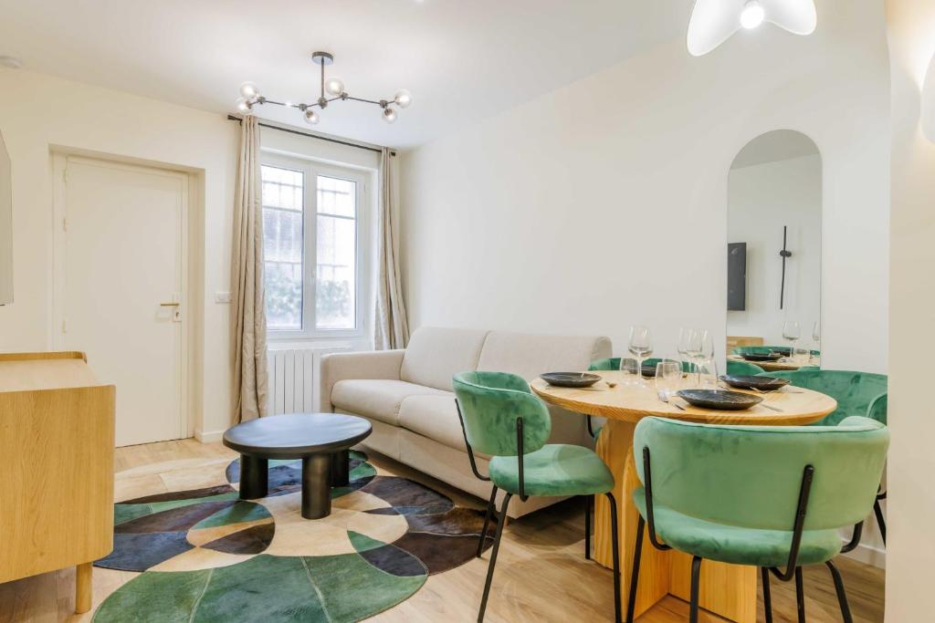 een woonkamer met een bank en een tafel en stoelen bij Modern Apartment near MontmartreSacré Cœur in Parijs