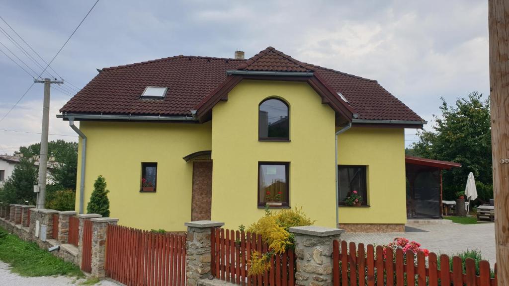 a yellow house with a brown roof at Apartmán Beáta in Levoča