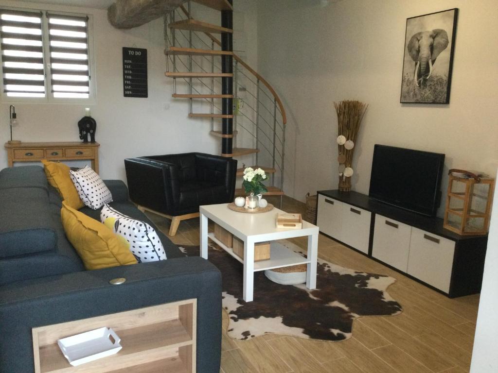 ein Wohnzimmer mit einem blauen Sofa und einem TV in der Unterkunft gites de terophey & kena in Thiberville