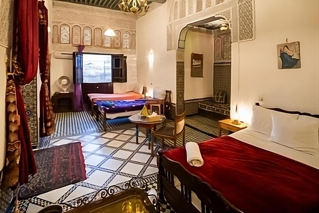 a hotel room with two beds and a couch at Fes Antique Hostel in Fez