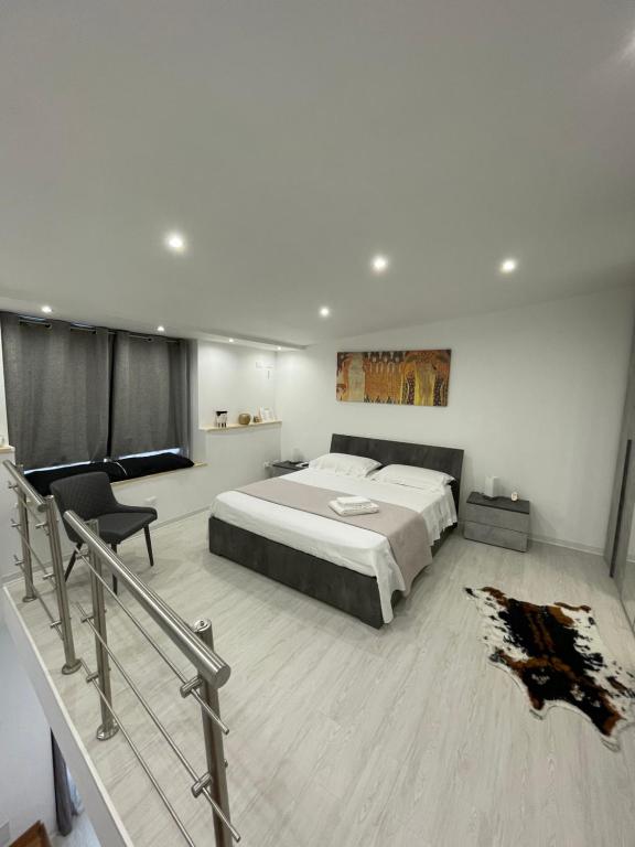1 dormitorio con 1 cama grande y 1 silla en La Casetta, en Caltabellotta