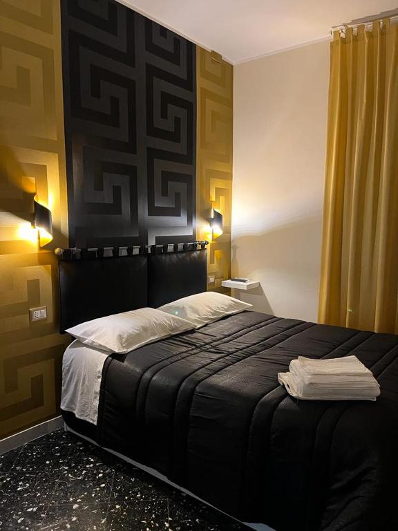 una camera con un grande letto con testiera nera di Golden a Barletta