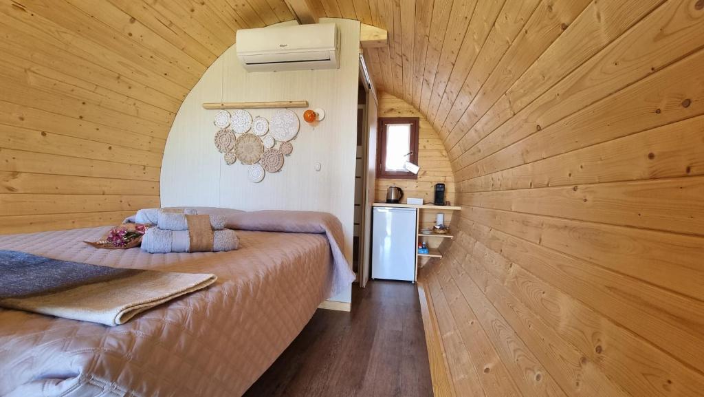 um pequeno quarto com uma cama num quarto de madeira em Dormire in una botte - Antiche Vigne Pironti 